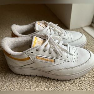 Well worn white platform Reebok sneakers with yellow stripe. US 7